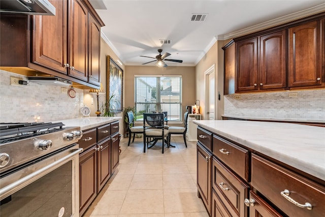 kitchen featuring visible vents, ornamental molding, stainless steel gas stove, light countertops, and a ceiling fan