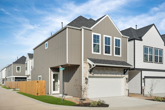 view of front of home featuring board and batten siding, fence, a garage, concrete driveway, and roof with shingles