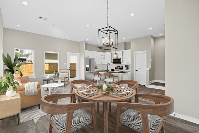 dining room with recessed lighting, baseboards, dark wood-style flooring, an inviting chandelier, and visible vents
