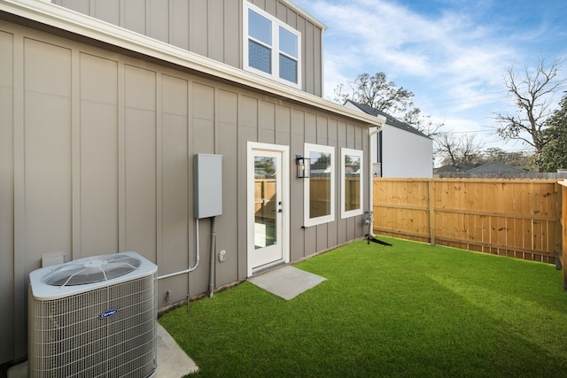 exterior space featuring cooling unit, board and batten siding, and fence