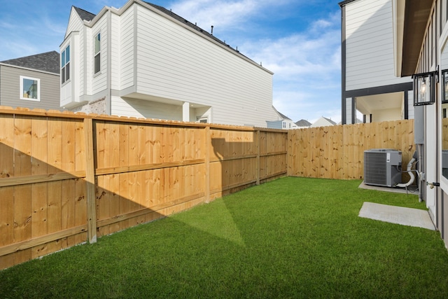 view of yard with central air condition unit and a fenced backyard