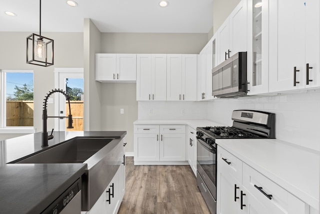 kitchen featuring a sink, stainless steel appliances, recessed lighting, decorative backsplash, and white cabinets