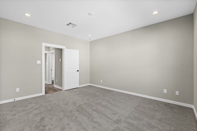 empty room featuring recessed lighting, visible vents, baseboards, and dark colored carpet