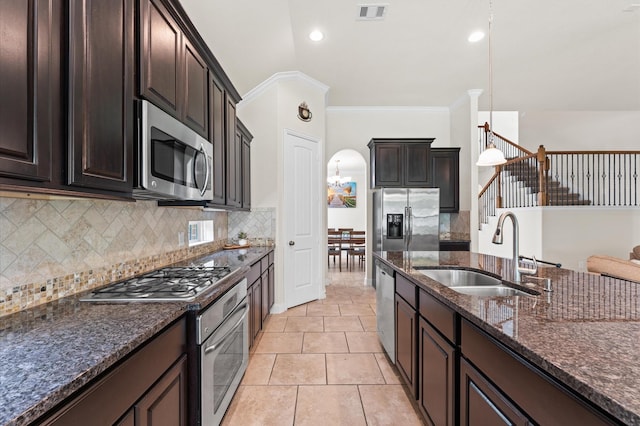 kitchen with decorative backsplash, visible vents, appliances with stainless steel finishes, arched walkways, and a sink