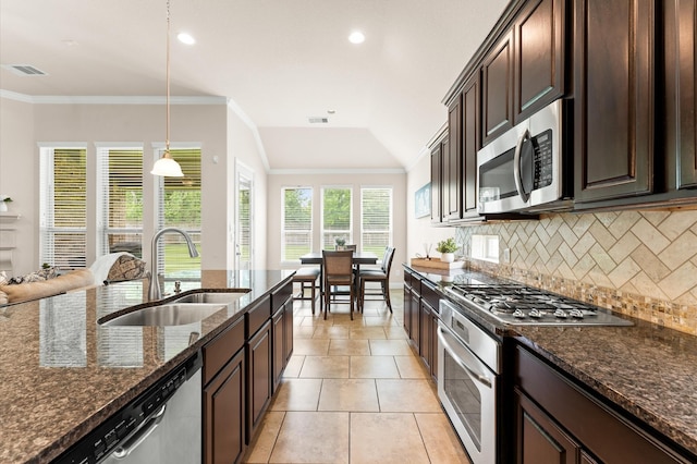 kitchen featuring dark brown cabinetry, backsplash, visible vents, a sink, and stainless steel appliances
