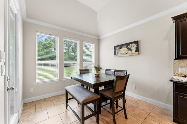 dining space with light tile patterned floors, baseboards, ornamental molding, and vaulted ceiling
