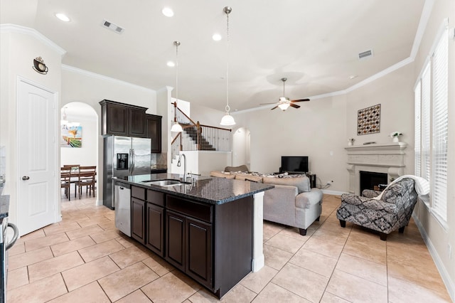 kitchen with a sink, arched walkways, appliances with stainless steel finishes, and visible vents