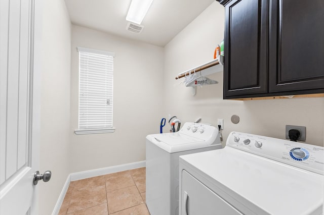 washroom with visible vents, light tile patterned flooring, baseboards, washing machine and clothes dryer, and cabinet space