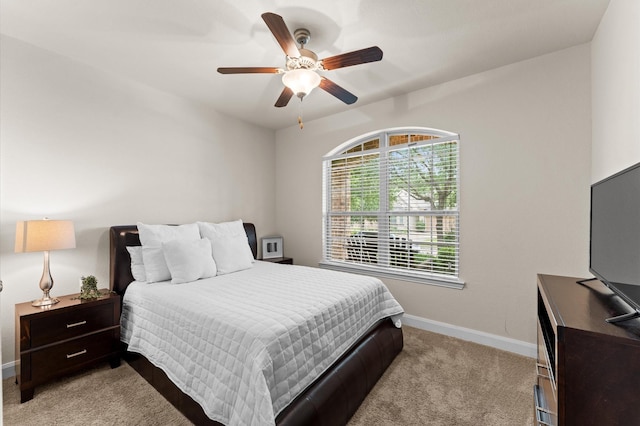 bedroom featuring baseboards, light carpet, and a ceiling fan