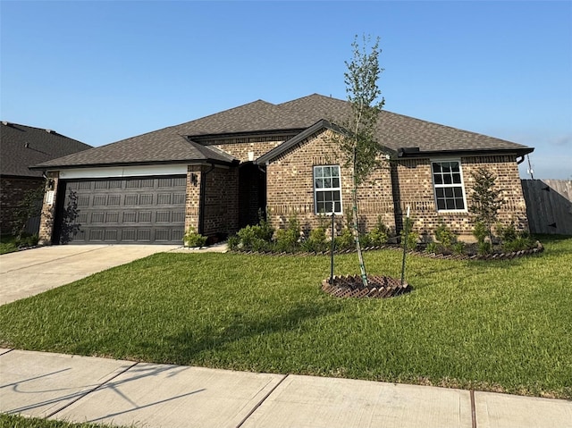 single story home featuring concrete driveway, a garage, brick siding, and a front yard