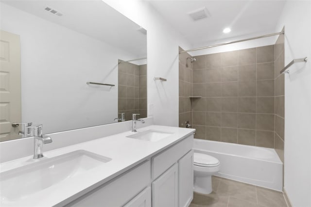 bathroom with a sink, toilet, visible vents, and tile patterned floors