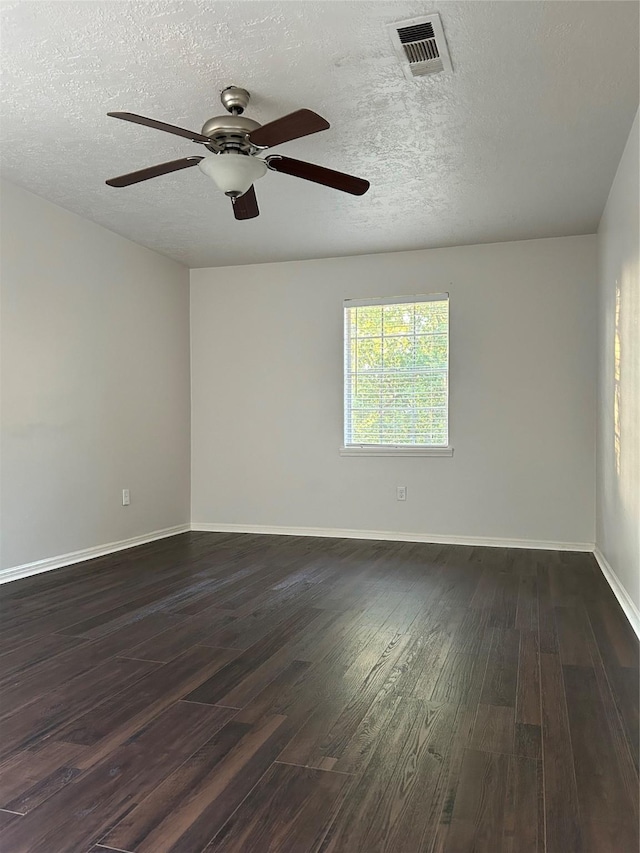 spare room with ceiling fan, dark wood-style floors, a textured ceiling, and visible vents