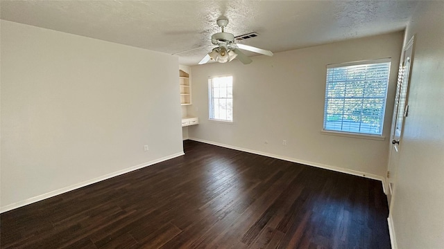 empty room featuring baseboards, a ceiling fan, wood finished floors, and visible vents