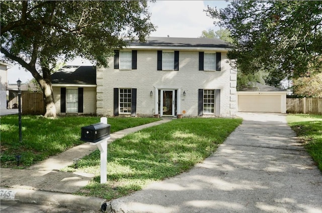 colonial home featuring brick siding, fence, and a front yard