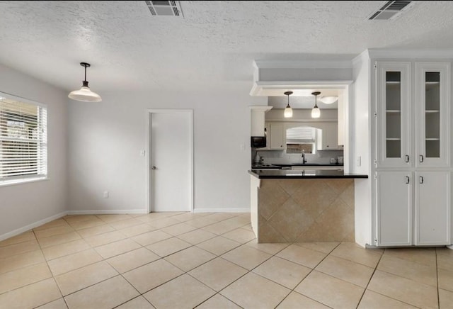 kitchen featuring dark countertops, visible vents, and a healthy amount of sunlight