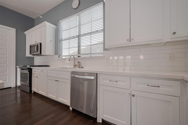 4318 E Center St, Houston, TX 77007 - kitchen with dark wood-type flooring, white cabinetry, a sink, appliances with stainless steel finishes, and backsplash