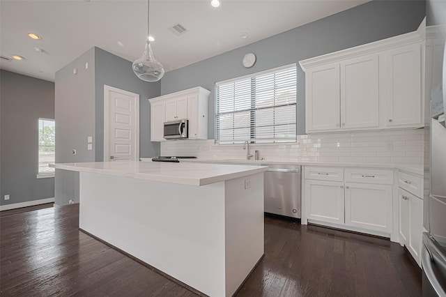 4318 E Center St, Houston, TX 77007 - kitchen with appliances with stainless steel finishes, tasteful backsplash, white cabinetry, dark wood-type flooring, and visible vents