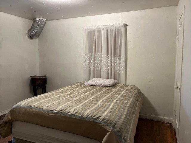 bedroom featuring baseboards and wood finished floors