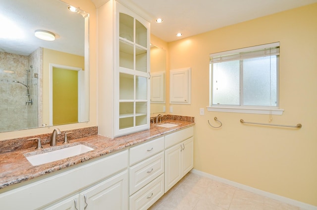 bathroom with a stall shower, double vanity, baseboards, tile patterned floors, and recessed lighting