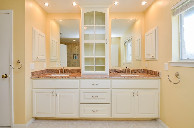 bathroom featuring double vanity, baseboards, and tile patterned floors