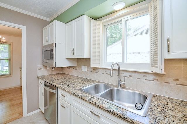 1915 Ashford Hollow Ln, Houston, TX 77077 - kitchen with stainless steel appliances, crown molding, white cabinets, backsplash, and light stone counters