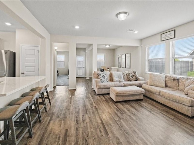 living room with recessed lighting and dark wood-style flooring