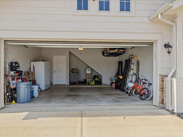 garage featuring freestanding refrigerator and driveway