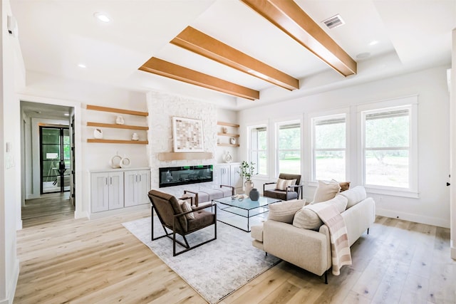 living room featuring baseboards, visible vents, a wealth of natural light, and light wood-style floors