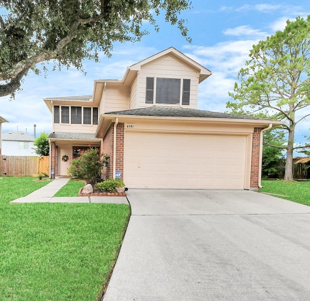 traditional home with brick siding, fence, driveway, and a front yard