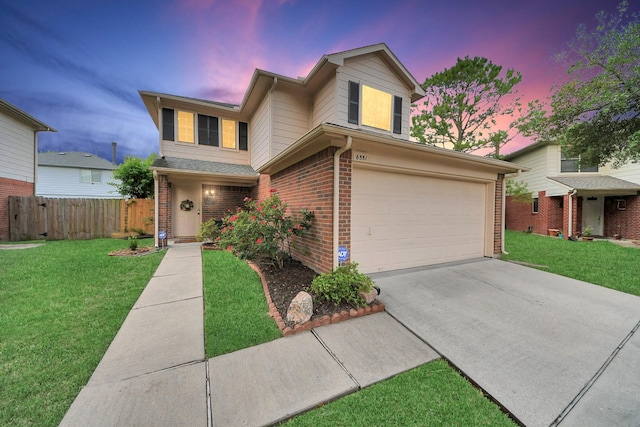 traditional-style home featuring a front yard, a garage, brick siding, fence, and concrete driveway