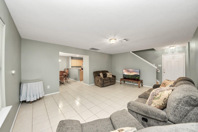living area with light tile patterned floors, baseboards, and visible vents