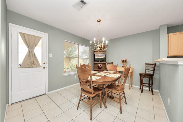 dining room with light tile patterned floors, baseboards, visible vents, and a chandelier