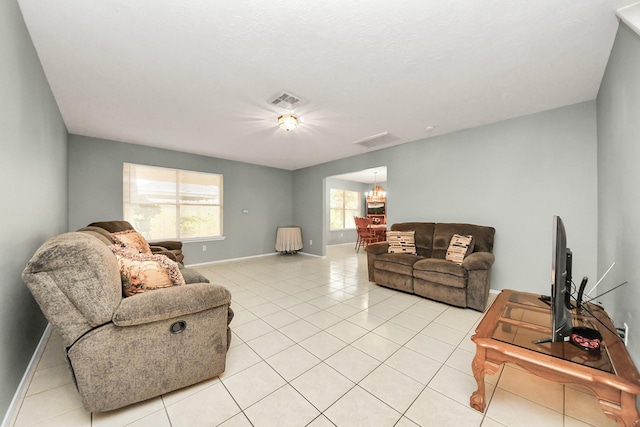 living room with baseboards, a notable chandelier, light tile patterned floors, and visible vents