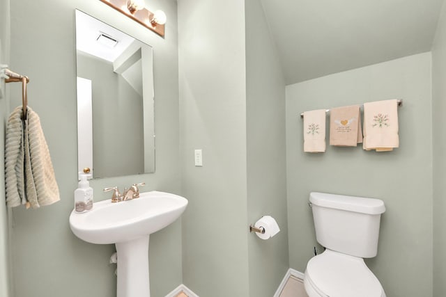 bathroom with baseboards, lofted ceiling, toilet, and visible vents