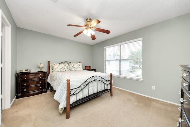 bedroom featuring baseboards, ceiling fan, and light carpet