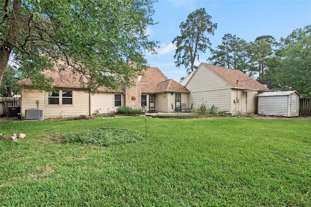 back of house with a lawn, cooling unit, an outdoor structure, a shed, and a patio