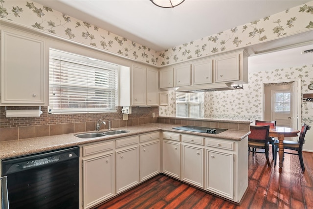 kitchen featuring dark wood-type flooring, a sink, black appliances, and wallpapered walls