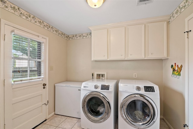 washroom featuring visible vents, washing machine and dryer, baseboards, cabinet space, and light tile patterned floors