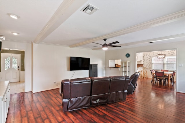 living room with crown molding, dark wood finished floors, beam ceiling, and visible vents