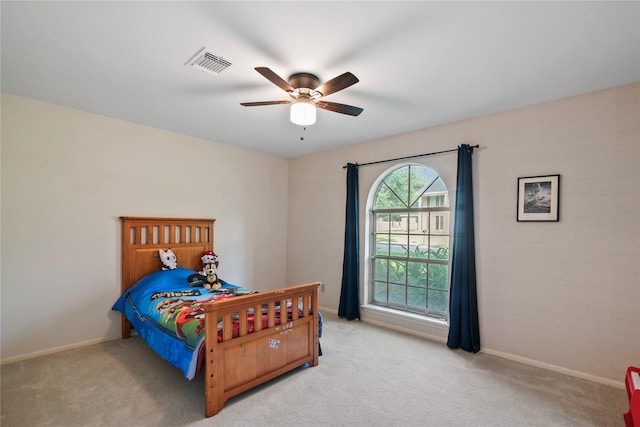 bedroom with baseboards, visible vents, and light carpet