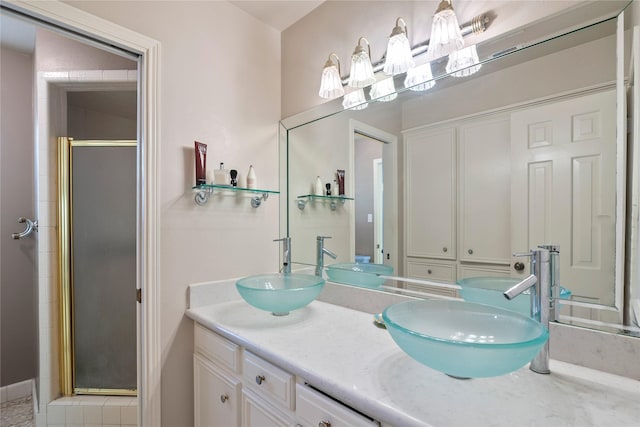 full bathroom featuring double vanity, a sink, and a stall shower