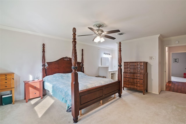 carpeted bedroom featuring ensuite bathroom, a ceiling fan, visible vents, baseboards, and ornamental molding