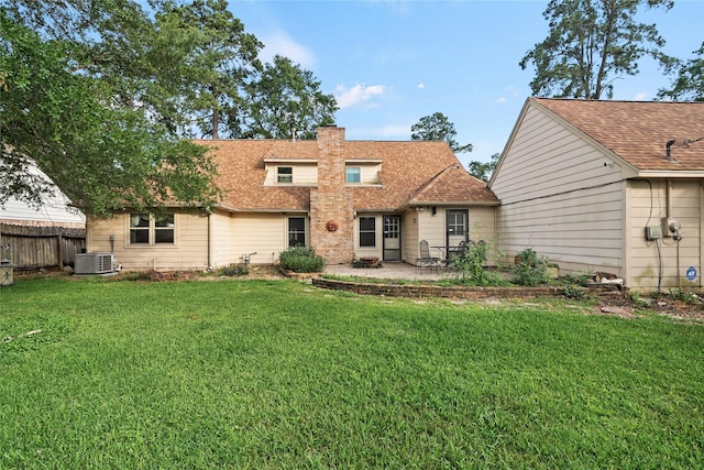 back of house featuring a patio area, fence, a yard, and a chimney