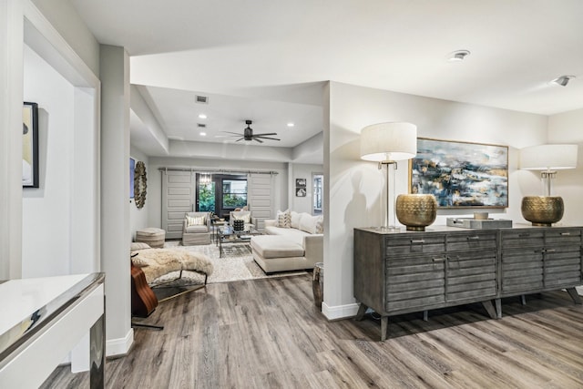 living room featuring a ceiling fan, visible vents, wood finished floors, baseboards, and recessed lighting