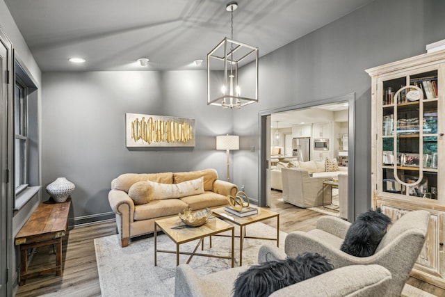 living room featuring an inviting chandelier, recessed lighting, and wood finished floors