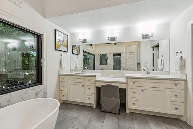 full bathroom featuring double vanity, a freestanding tub, a shower stall, and a sink