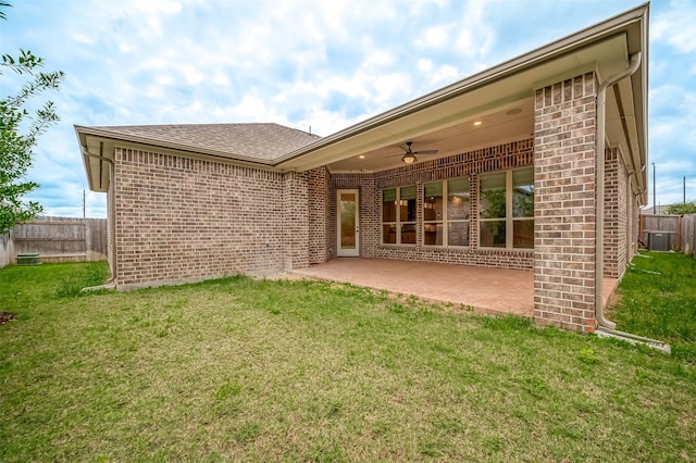 rear view of house with brick siding, ceiling fan, fence, and a yard