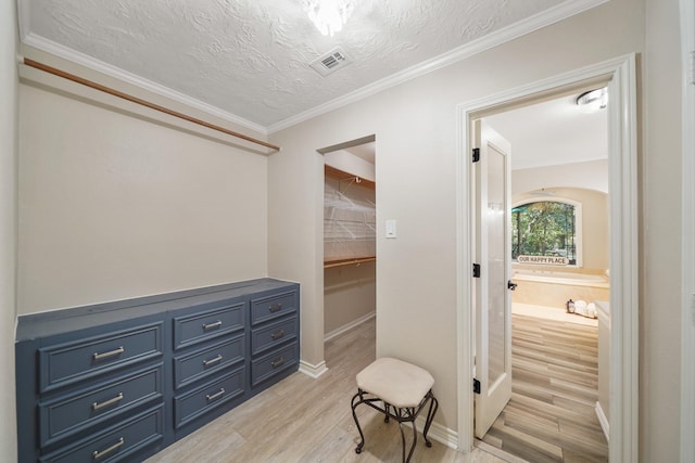 302 Tall Pines Dr, Magnolia, TX 77354 - interior space featuring a textured ceiling, visible vents, crown molding, light wood-type flooring, and baseboards