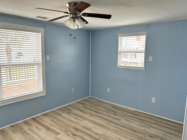 16717 Captain Hook, Jamaica Beach, TX 77554 - unfurnished room with light wood-type flooring, a ceiling fan, a textured ceiling, and visible vents