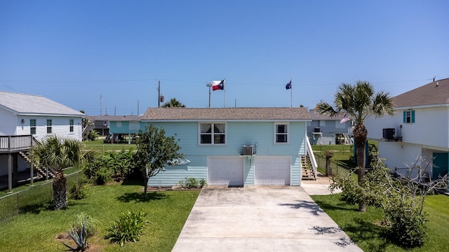 16717 Captain Hook, Jamaica Beach, TX 77554 - view of front of house featuring a front lawn, fence, concrete driveway, an attached garage, and stairway